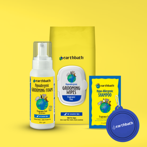 Earthbath pet grooming products including foam, wipes, shampoo packets, and a carabiner on a yellow background.