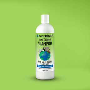 Bottle of earthbath Shed Control Shampoo on a green background